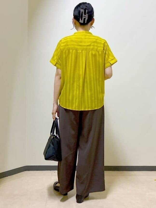 イエロー系のシャツ/ブラウス、ブラウン系のその他パンツ、ブラック系のトートバッグを着用したレディースの夏コーディネートの3枚目の写真