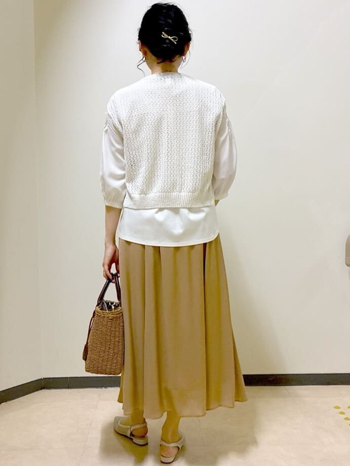 ホワイト系のシャツ/ブラウス、ベージュ系のニット/セーター、イエロー系のスカートを着用したレディースの夏コーディネートの3枚目の写真