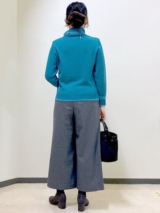 ブルー系のニット/セーター、グレー系のその他パンツ、ブラック系のダウンジャケット/コートを着用したレディースの冬コーディネートの3枚目の写真