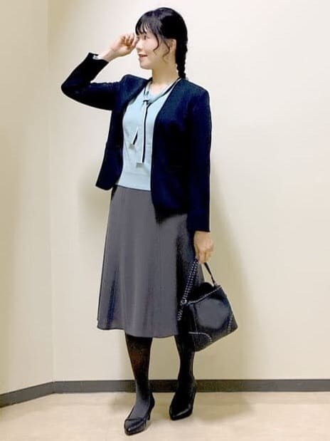 ブルー系のノーカラージャケット、ブルー系のニット/セーター、グレー系のスカートを着用したレディースの秋コーディネートの5枚目の写真