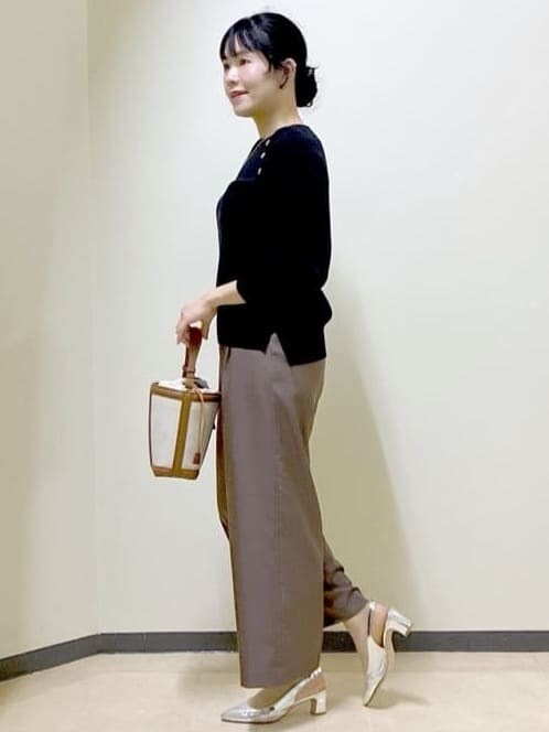 ブラウン系のその他パンツ、ブラック系のニット/セーター、イエロー系のショルダーバッグを着用したレディースの冬コーディネートの2枚目の写真
