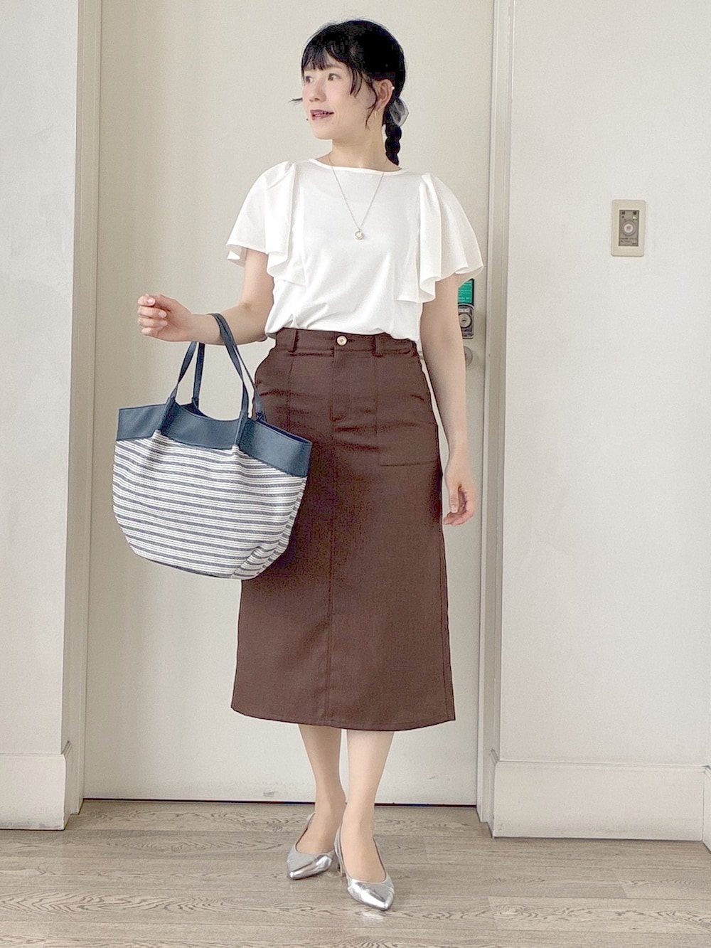 ホワイト系のTシャツ/カットソー、ブラック系のブルゾン、ブラウン系のスカートを着用したレディースの夏コーディネートの9枚目の写真