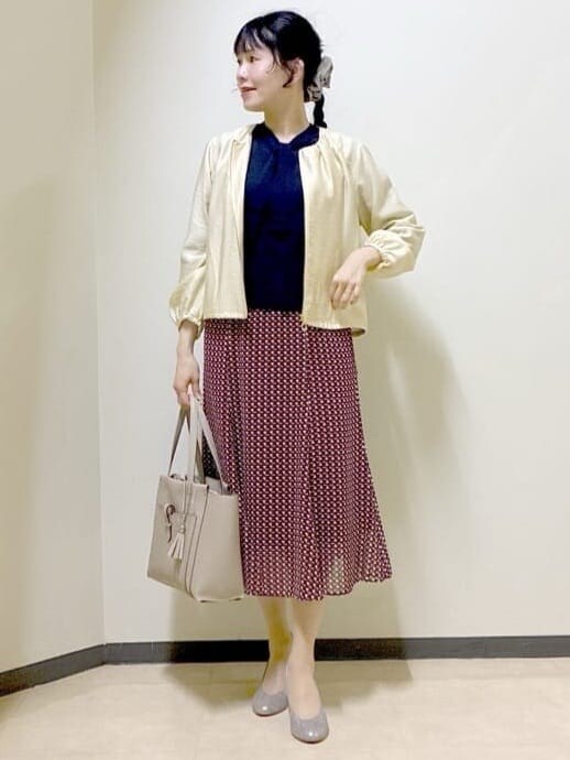 ベージュ系のブルゾン、ブルー系のニット/セーター、レッド系のスカートを着用したレディースの春コーディネートの8枚目の写真