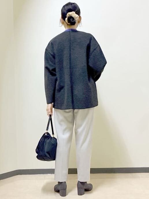 グレー系のノーカラーコート、パープル系のニット/セーター、ベージュ系のその他パンツを着用したレディースの冬コーディネートの3枚目の写真