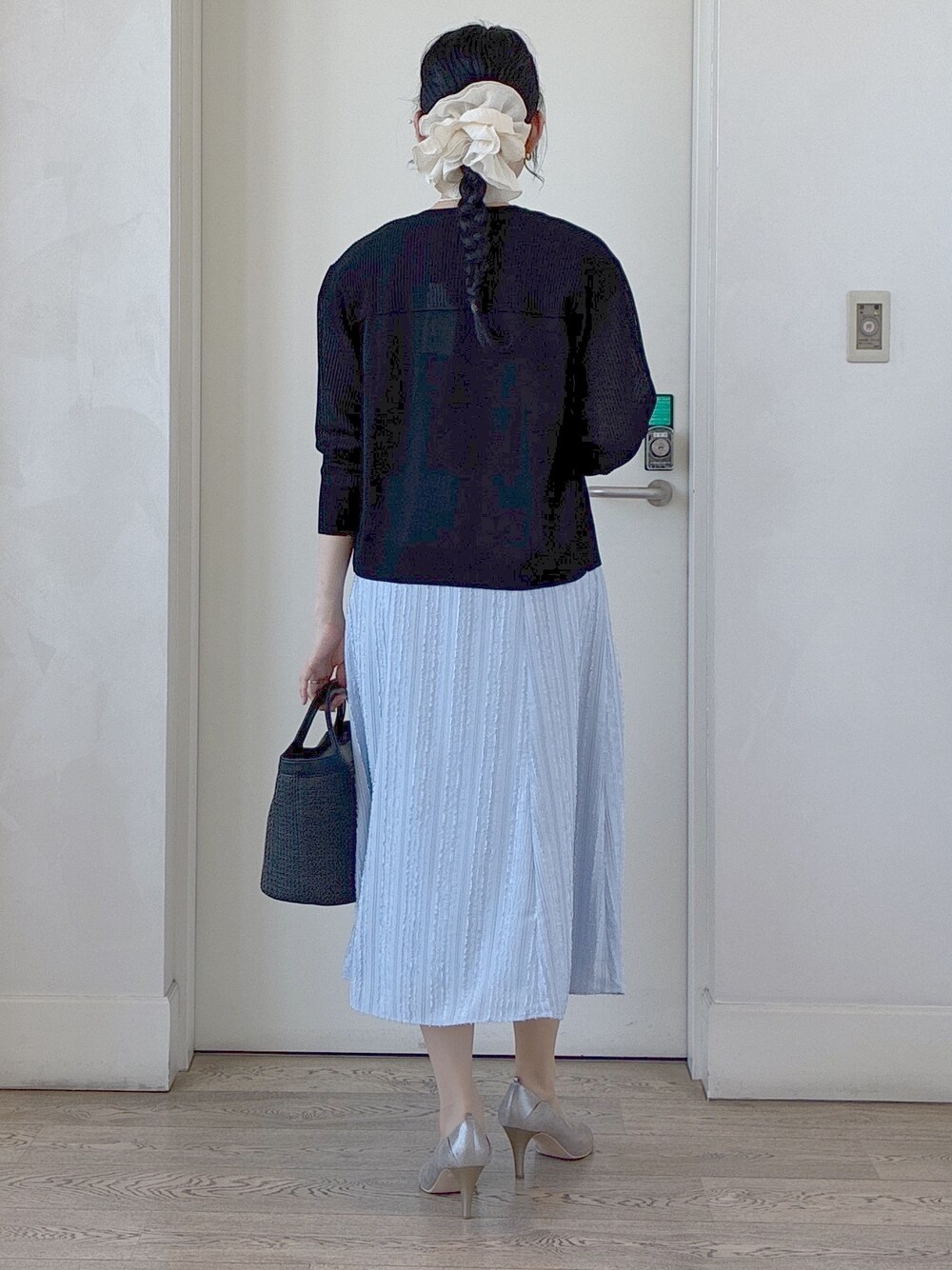ブラック系のカーディガン/ボレロ、ブラウン系のシャツ/ブラウス、ブルー系のスカートを着用したレディースの春コーディネートの3枚目の写真
