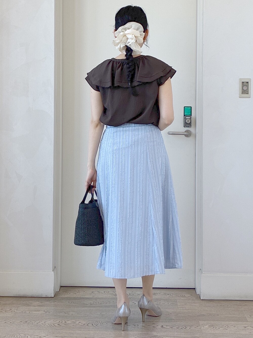 ブラウン系のシャツ/ブラウス、ブルー系のスカート、ベージュ系のタンクトップを着用したレディースの春コーディネートの3枚目の写真