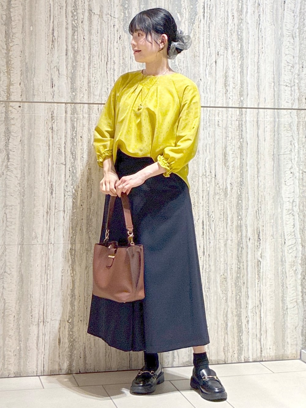 イエロー系のシャツ/ブラウス、ブルー系のその他パンツ、ブラウン系のトートバッグを着用したレディースの秋コーディネートの6枚目の写真