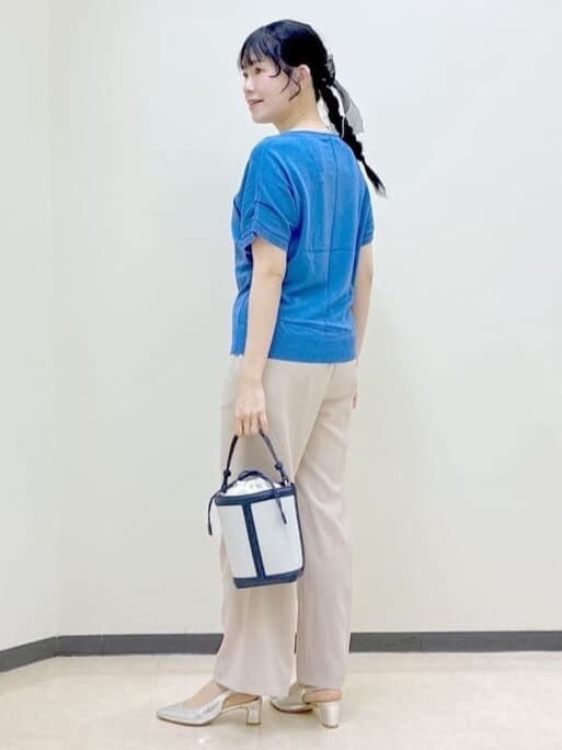 ベージュ系のその他パンツ、ブルー系のニット/セーター、ブルー系のショルダーバッグを着用したレディースの春コーディネートの4枚目の写真