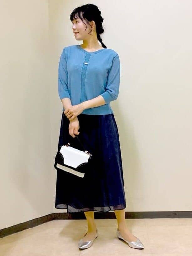ブルー系のニット/セーター、ブルー系のスカート、ベージュ系のショルダーバッグを着用したレディースの夏コーディネートの5枚目の写真