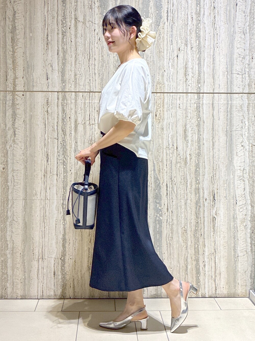 ホワイト系のTシャツ/カットソー、イエロー系のカーディガン/ボレロ、ブルー系のスカートを着用したレディースの夏コーディネートの2枚目の写真