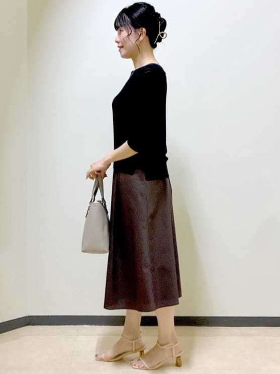 ブラック系のニット/セーター、グレー系のニット/セーター、ブラウン系のスカートを着用したレディースの夏コーディネートの2枚目の写真