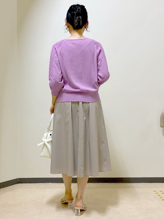 ピンク系のニット/セーター、ベージュ系のスカート、ブルー系のスカートを着用したレディースの夏コーディネートの3枚目の写真