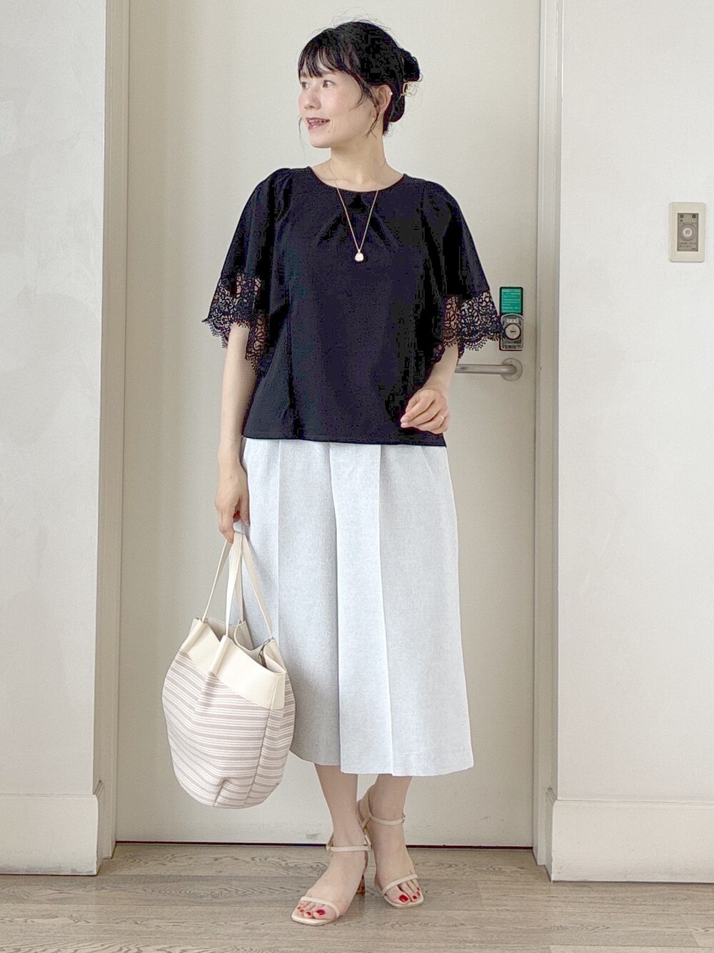 ブラック系のTシャツ/カットソー、グレー系のその他パンツ、ベージュ系のトートバッグを着用したレディースの夏コーディネートの9枚目の写真