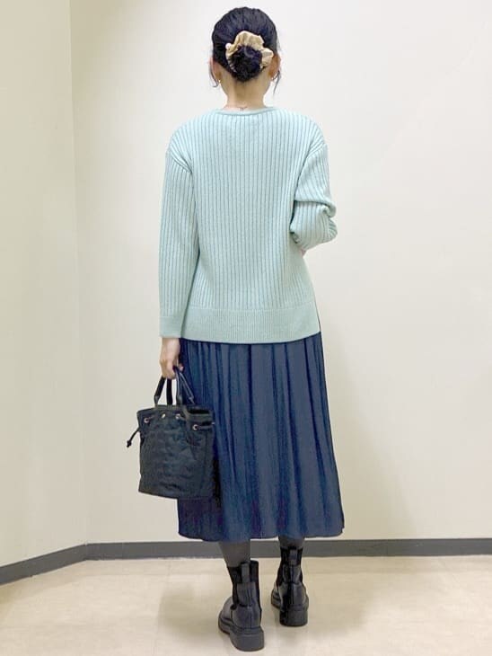 グリーン系のニット/セーター、ブルー系のその他パンツ、ベージュ系のノーカラーコートを着用したレディースの冬コーディネートの3枚目の写真
