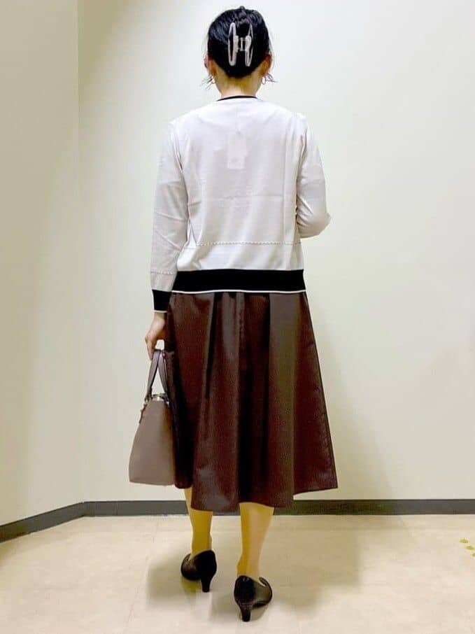 ベージュ系のカーディガン/ボレロ、ベージュ系のニット/セーター、ブラウン系のスカートを着用したレディースの夏コーディネートの4枚目の写真