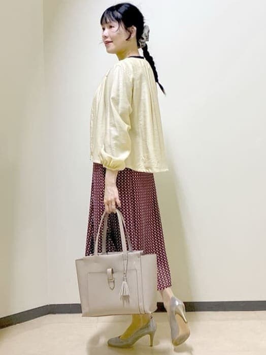 ベージュ系のブルゾン、ブルー系のニット/セーター、レッド系のスカートを着用したレディースの春コーディネートの4枚目の写真