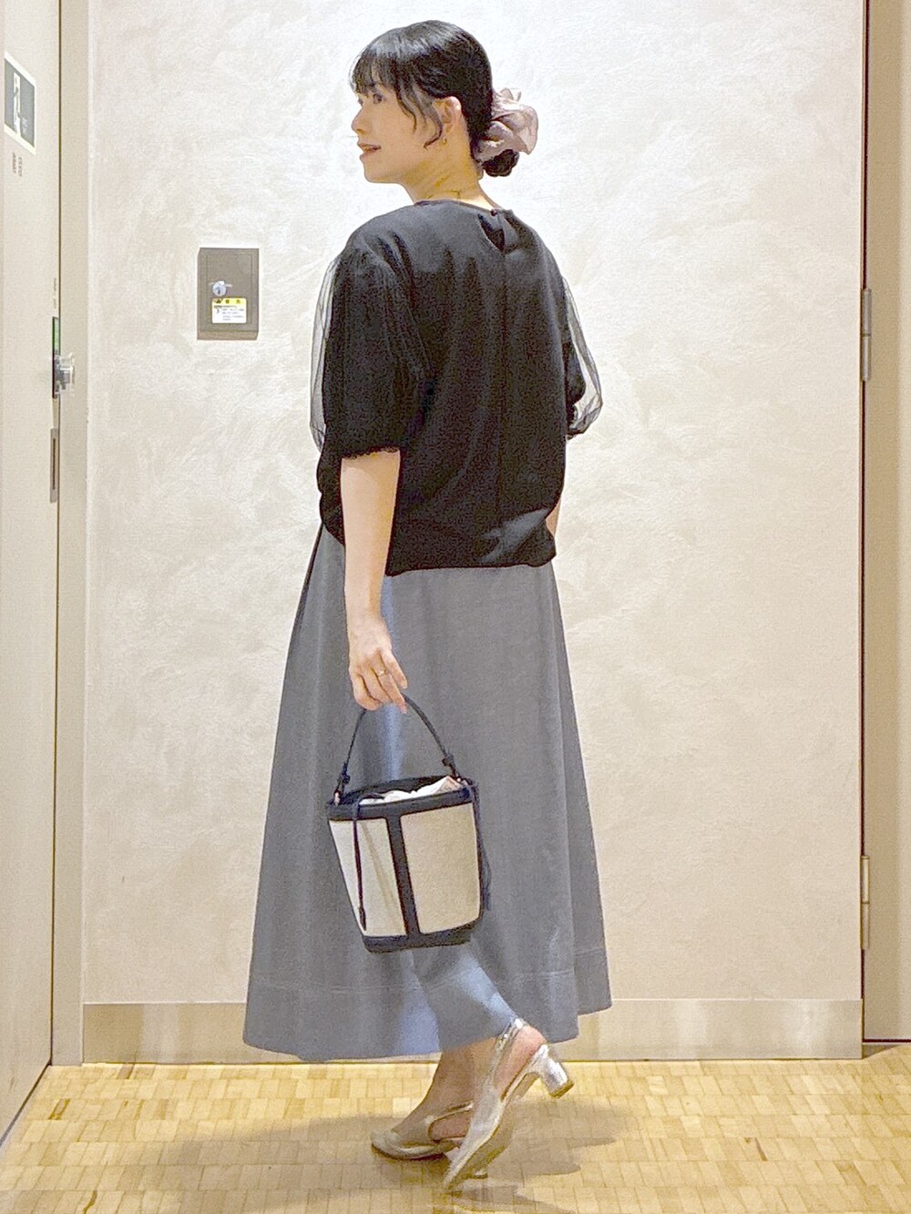 ブラック系のTシャツ/カットソー、ブルー系のスカート、ブルー系のショルダーバッグを着用したレディースの夏コーディネートの4枚目の写真