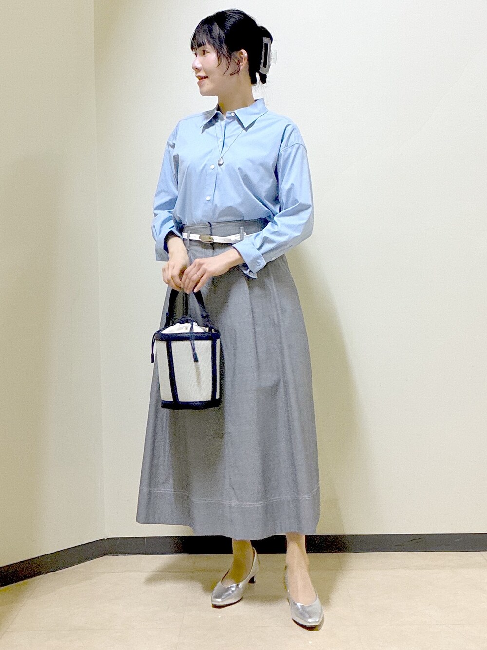 ブルー系のシャツ/ブラウス、ブルー系のニット/セーター、ブラック系のスカートを着用したレディースの春コーディネートの6枚目の写真