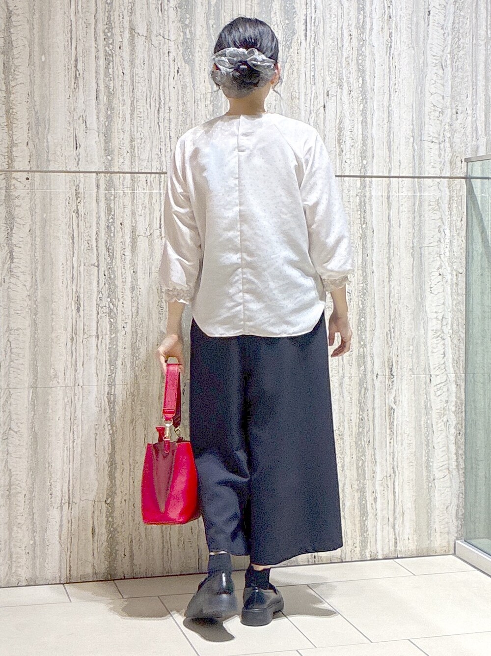 ベージュ系のシャツ/ブラウス、ブルー系のその他パンツ、レッド系のトートバッグを着用したレディースの秋コーディネートの3枚目の写真