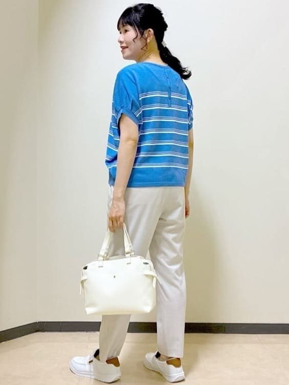 ブルー系のニット/セーター、ベージュ系のその他パンツ、ホワイト系のトートバッグを着用したレディースの夏コーディネートの4枚目の写真