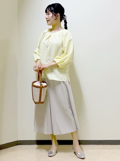 イエロー系のシャツ/ブラウス、シルバー系のパンプス、イエロー系のショルダーバッグを着用したレディースの春コーディネートの3枚目の写真