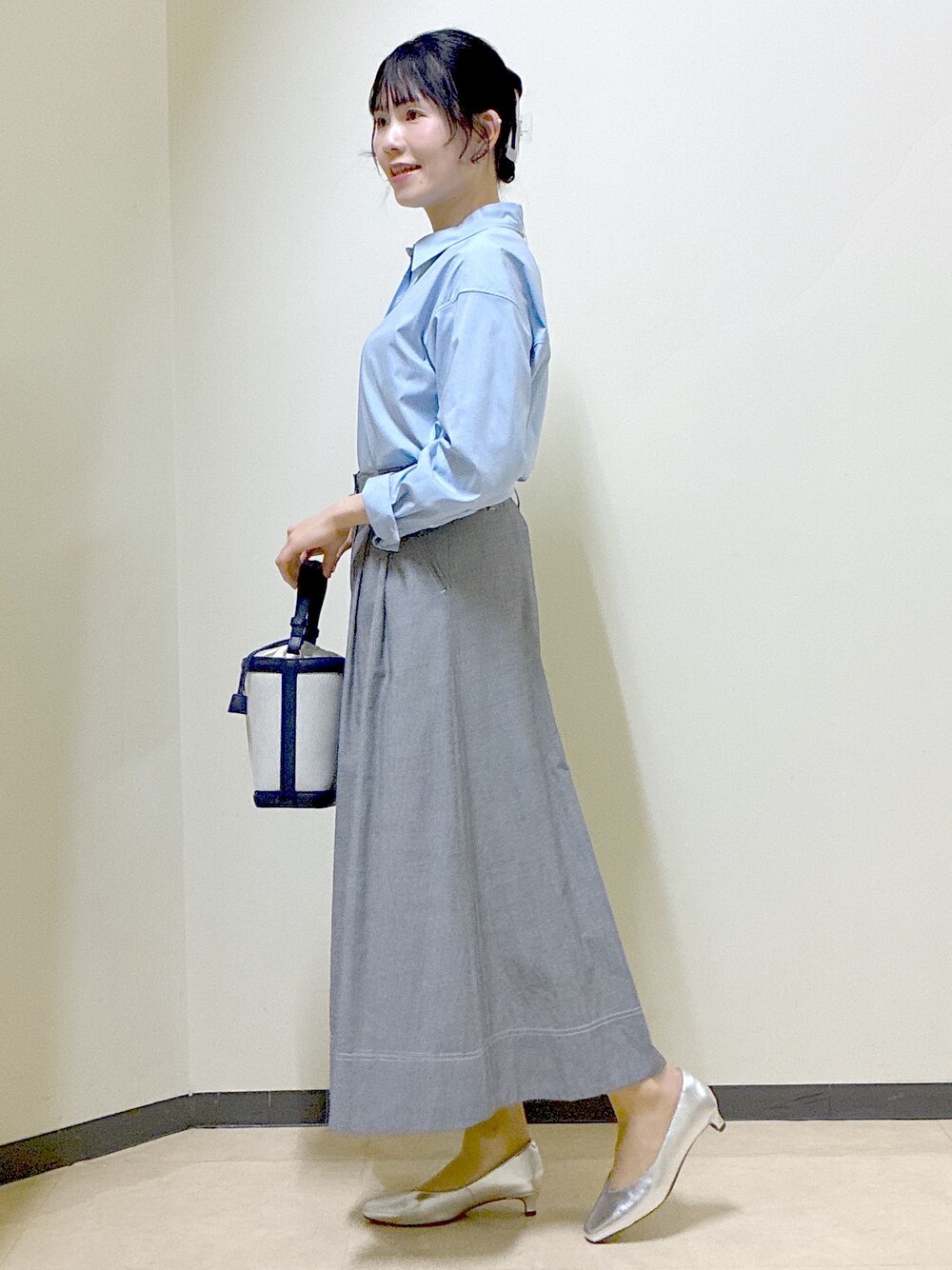 ブルー系のシャツ/ブラウス、ブルー系のニット/セーター、ブラック系のスカートを着用したレディースの春コーディネートの2枚目の写真