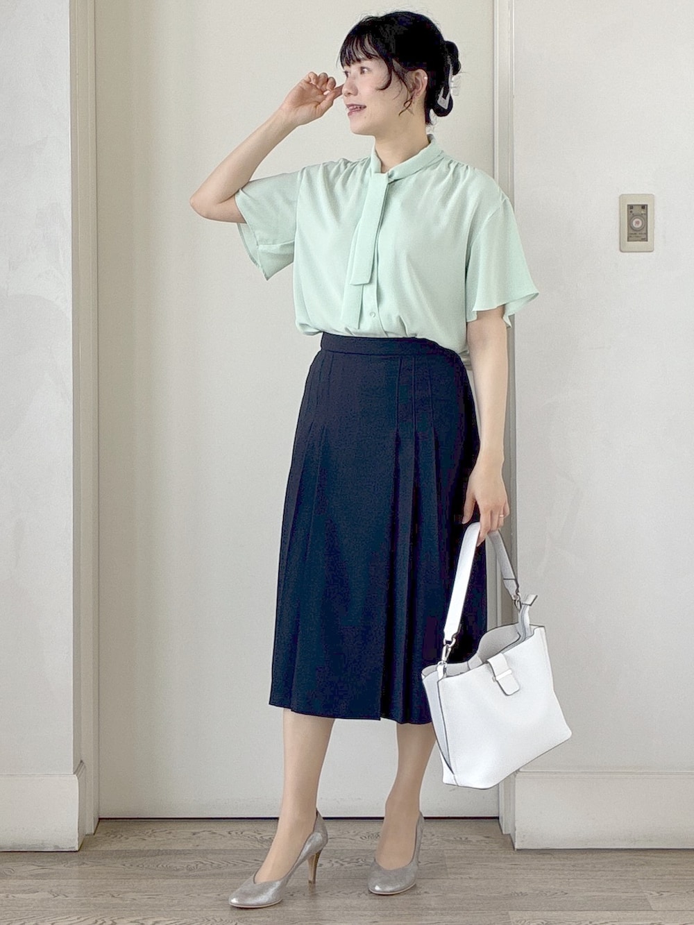 グレー系のテーラードジャケット、ホワイト系のトートバッグ、ブルー系のスカートを着用したレディースの春コーディネートの8枚目の写真