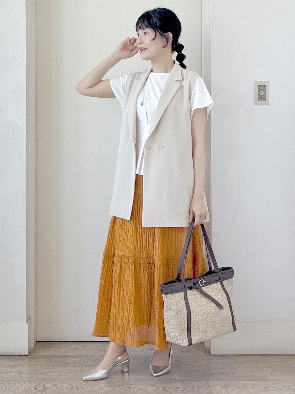 ホワイト系のTシャツ/カットソー、オレンジ系のスカート、イエロー系のトートバッグを着用したレディースの夏コーディネートの6枚目の写真