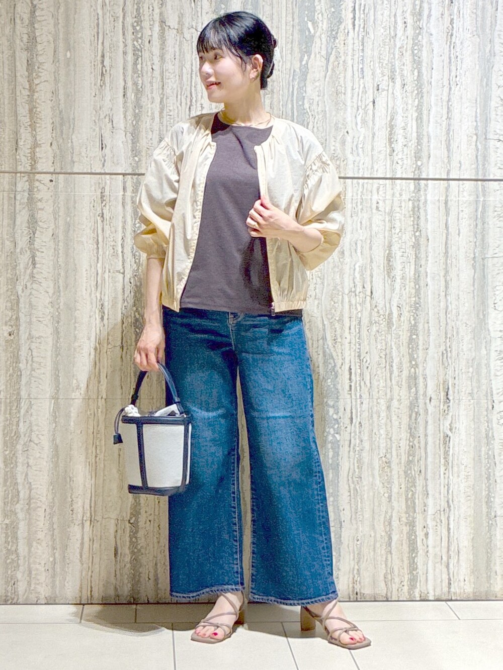 ベージュ系のブルゾン、ブラウン系のTシャツ/カットソー、ブルー系のデニムパンツを着用したレディースの夏コーディネートの8枚目の写真