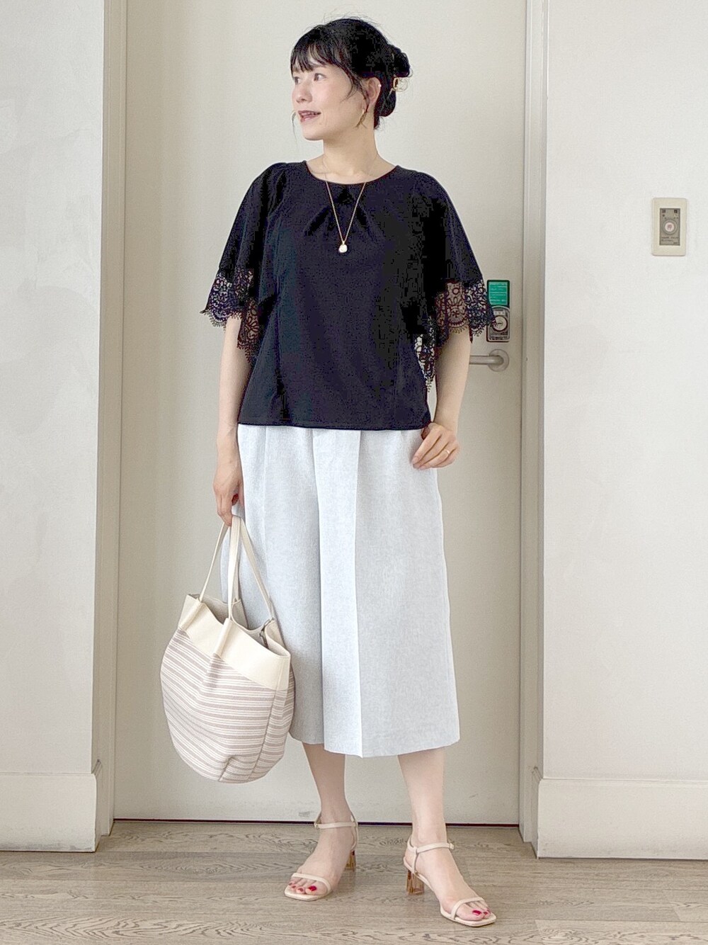 ブラック系のTシャツ/カットソー、グレー系のその他パンツ、ベージュ系のトートバッグを着用したレディースの夏コーディネートの10枚目の写真