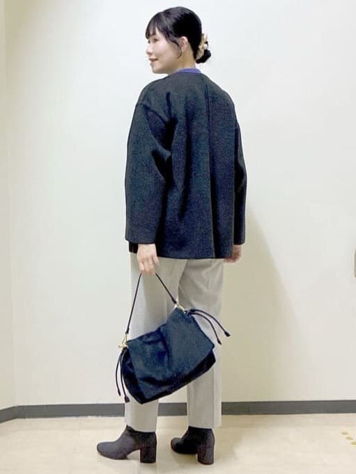 グレー系のノーカラーコート、パープル系のニット/セーター、ベージュ系のその他パンツを着用したレディースの冬コーディネートの4枚目の写真
