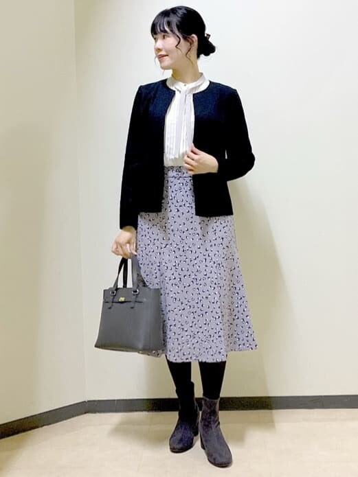 ホワイト系のシャツ/ブラウス、グレー系のスカート、ブラック系のノーカラージャケットを着用したレディースの冬コーディネートの7枚目の写真