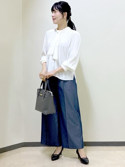 ホワイト系のシャツ/ブラウス、ブラック系のベスト、ブルー系のその他パンツを着用したレディースの秋コーディネートの6枚目の写真