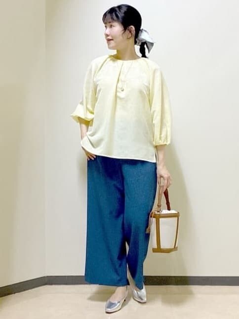 イエロー系のシャツ/ブラウス、シルバー系のパンプス、ブルー系のその他パンツを着用したレディースの冬コーディネートの7枚目の写真