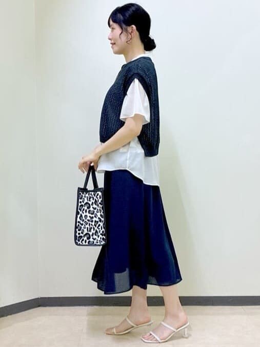 ベージュ系のシャツ/ブラウス、ブラック系のニット/セーター、ブルー系のスカートを着用したレディースの夏コーディネートの2枚目の写真