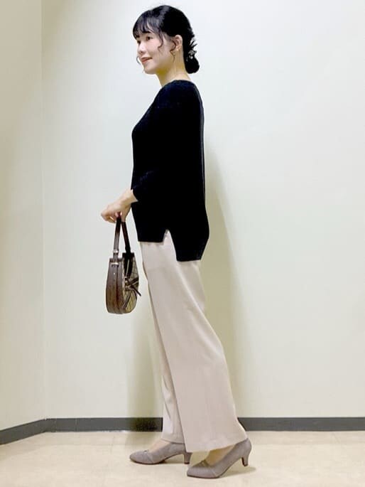 ブラック系のニット/セーター、ベージュ系のその他パンツ、イエロー系のショルダーバッグを着用したレディースの秋コーディネートの2枚目の写真