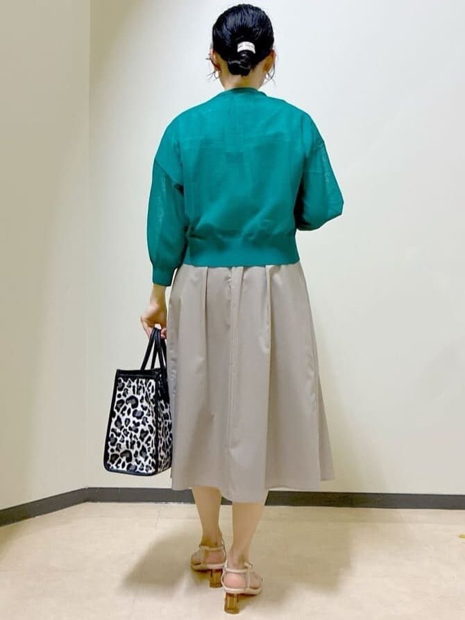 グリーン系のカーディガン/ボレロ、ホワイト系のシャツ/ブラウス、ベージュ系のスカートを着用したレディースの夏コーディネートの3枚目の写真