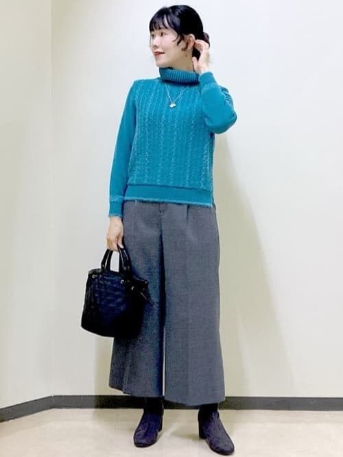 ブルー系のニット/セーター、グレー系のその他パンツ、ブラック系のダウンジャケット/コートを着用したレディースの冬コーディネートの7枚目の写真