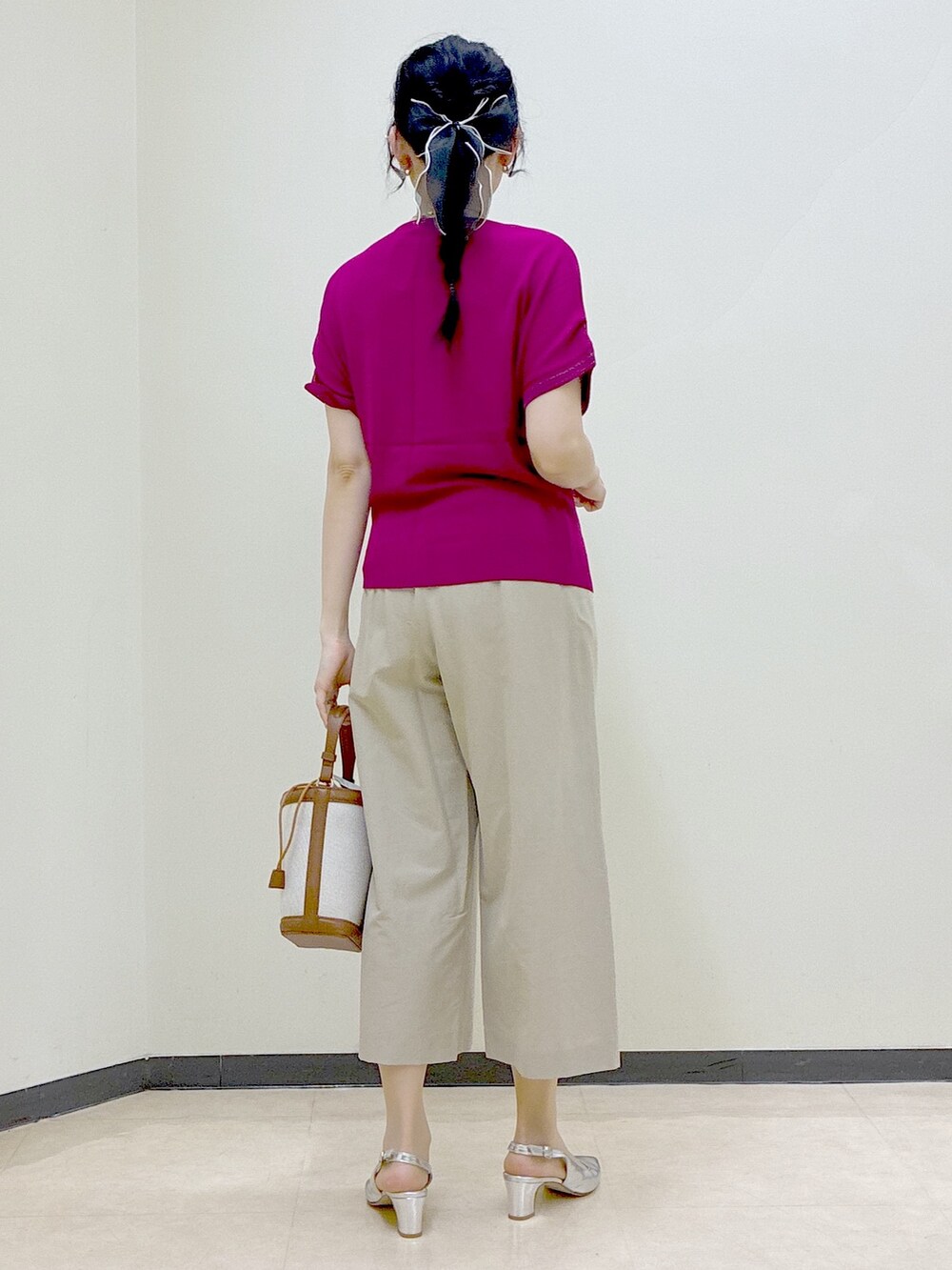 ピンク系のニット/セーター、ベージュ系のその他パンツ、イエロー系のショルダーバッグを着用したレディースの春コーディネートの3枚目の写真