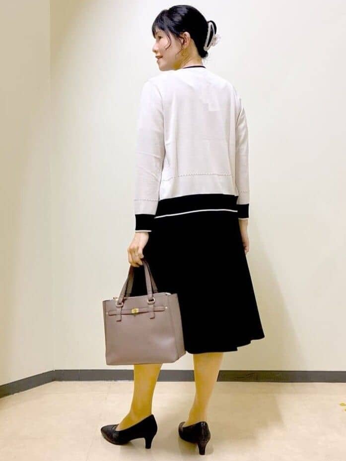 ベージュ系のカーディガン/ボレロ、ベージュ系のニット/セーター、ブラック系のスカートを着用したレディースの秋コーディネートの4枚目の写真