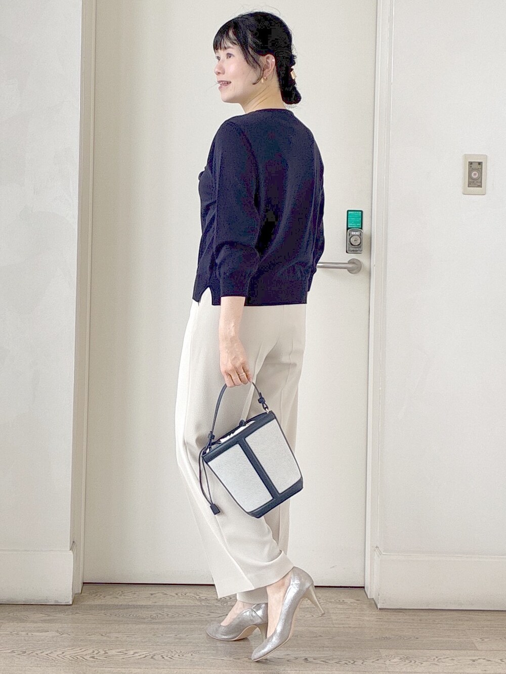 ブルー系のニット/セーター、ベージュ系のその他パンツ、ブルー系のショルダーバッグを着用したレディースの夏コーディネートの4枚目の写真