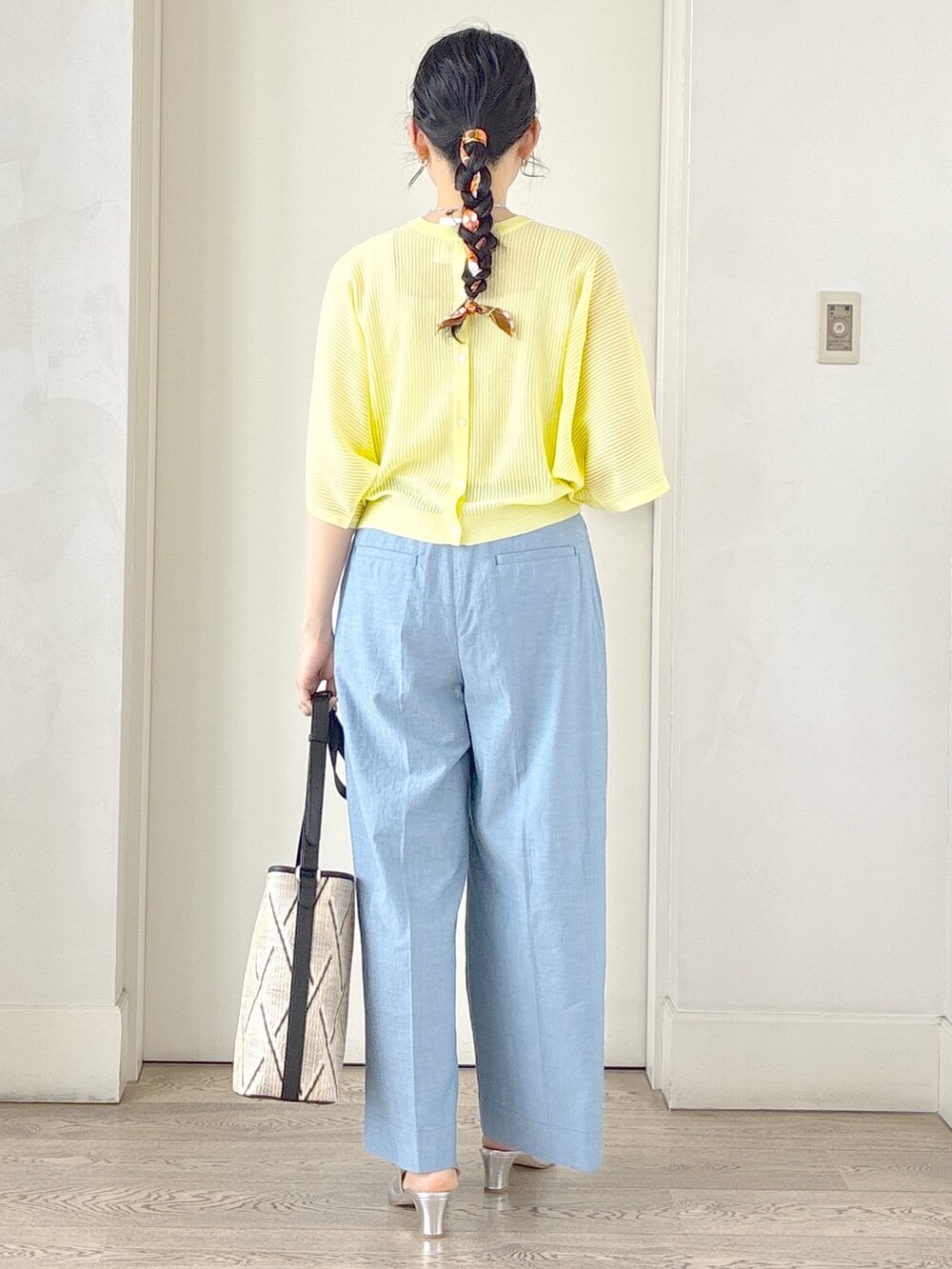 ブルー系のその他パンツ、ベージュ系のショルダーバッグ、イエロー系のニット/セーターを着用したレディースの春コーディネートの3枚目の写真