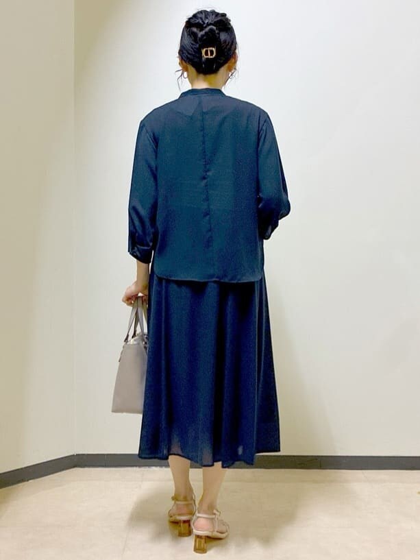 ブルー系のシャツ/ブラウス、ブルー系のスカート、ベージュ系のニット/セーターを着用したレディースの夏コーディネートの3枚目の写真