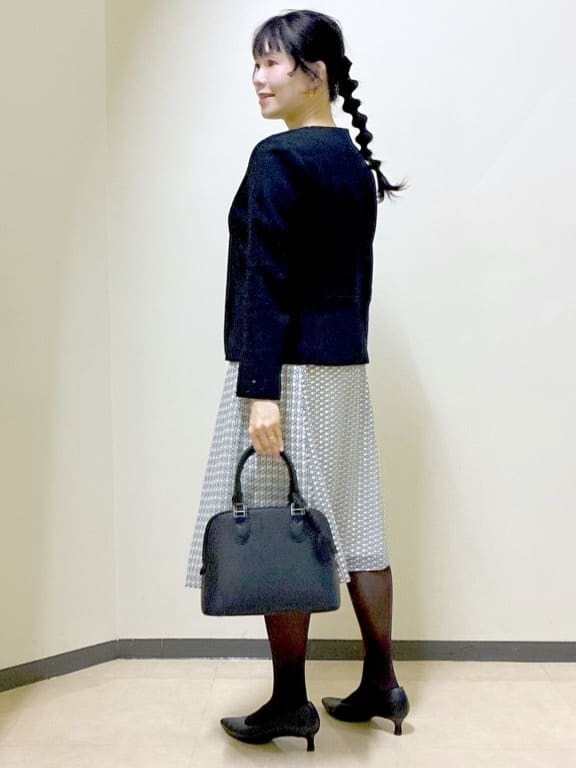 ブラック系のノーカラージャケット、ベージュ系のシャツ/ブラウス、ベージュ系のスカートを着用したレディースの冬コーディネートの4枚目の写真