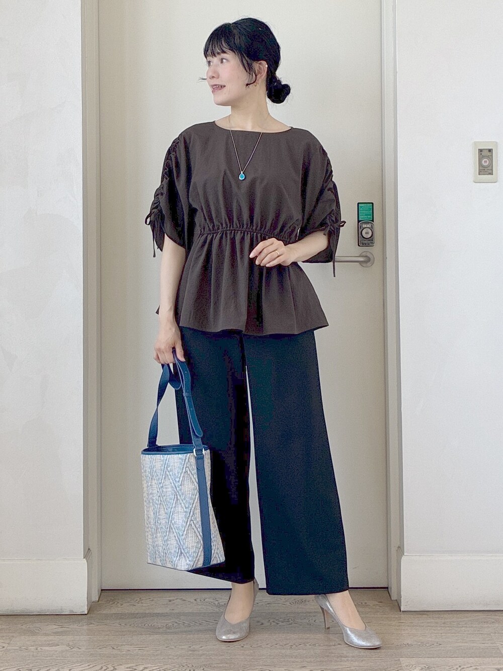 ブラック系のその他パンツ、ブルー系のショルダーバッグ、ホワイト系のカーディガン/ボレロを着用したレディースの春コーディネートの7枚目の写真