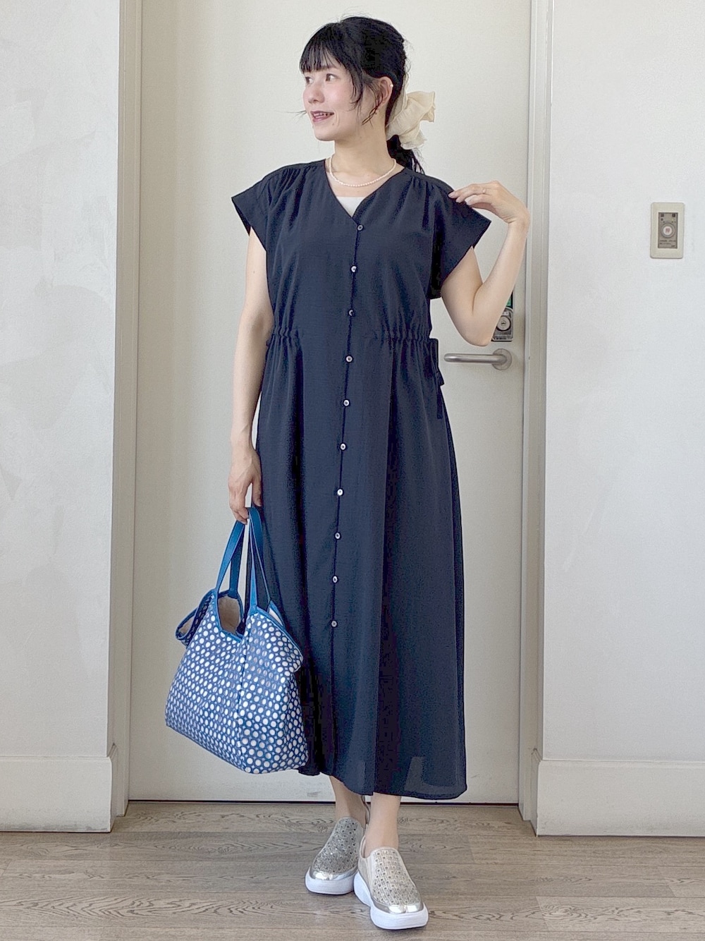 ブルー系のワンピース、ベージュ系のタンクトップ、ブルー系のブルゾンを着用したレディースの春コーディネートの9枚目の写真