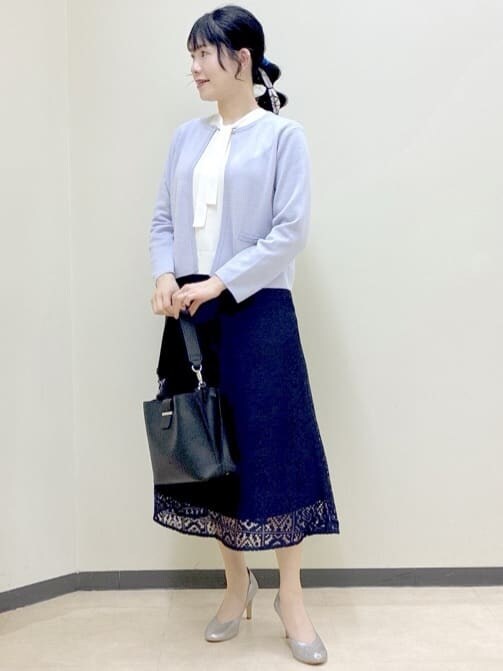 パープル系のカーディガン/ボレロ、ホワイト系のニット/セーター、ブルー系のスカートを着用したレディースの春コーディネートの8枚目の写真