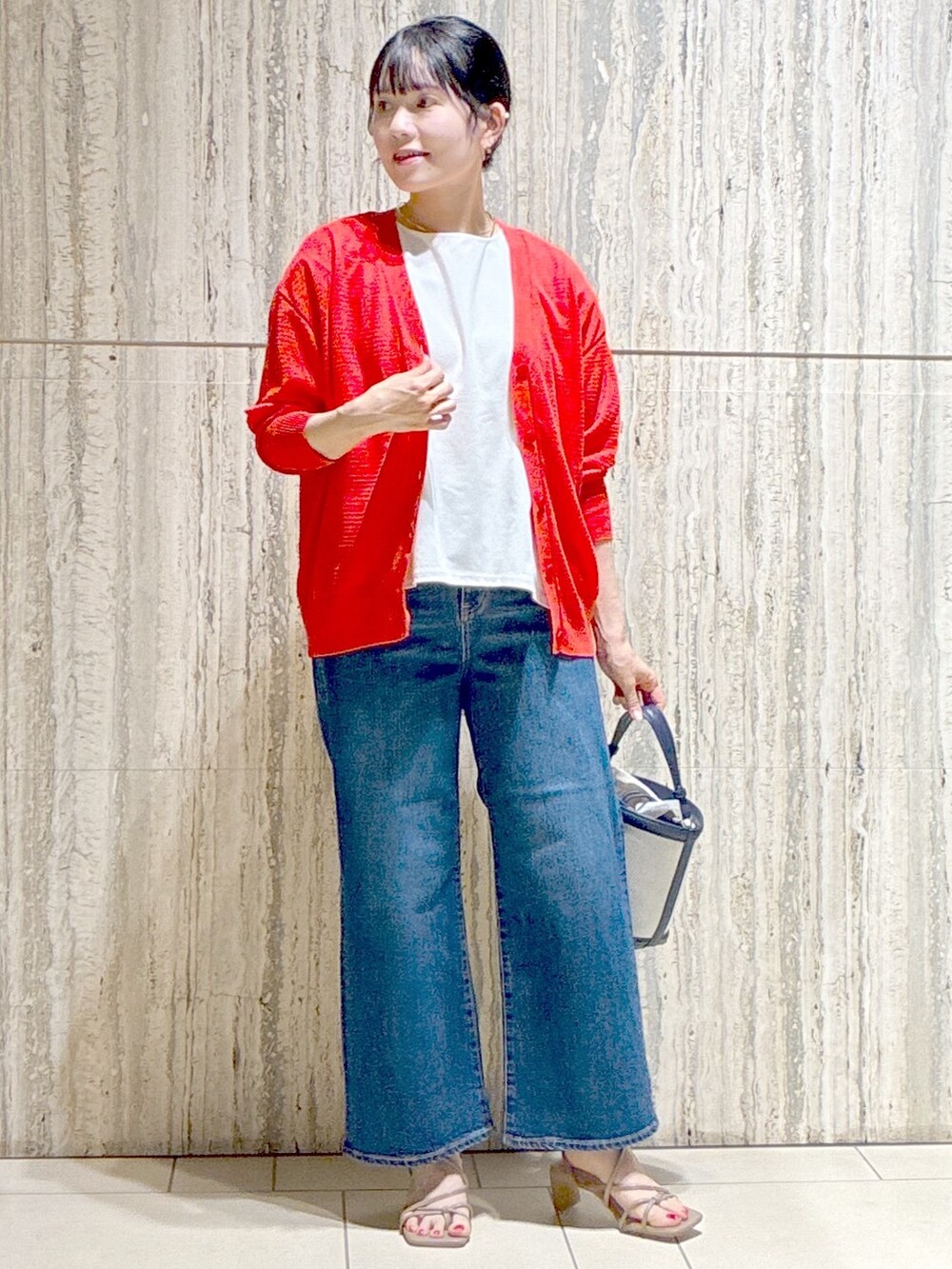 オレンジ系のカーディガン/ボレロ、ホワイト系のチュニック、ブルー系のデニムパンツを着用したレディースの夏コーディネートの7枚目の写真
