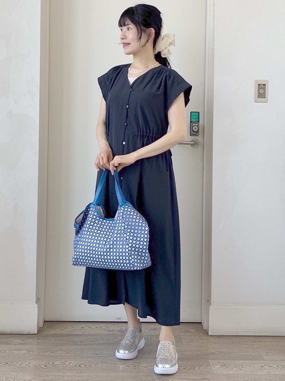ブルー系のワンピース、ベージュ系のタンクトップ、ブルー系のブルゾンを着用したレディースの春コーディネートの8枚目の写真