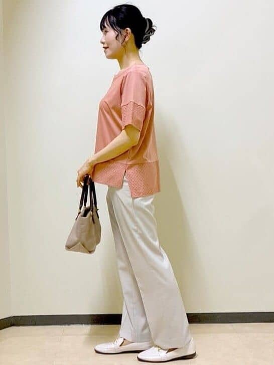 オレンジ系のTシャツ/カットソー、ベージュ系のその他パンツ、ベージュ系のトートバッグを着用したレディースの夏コーディネートの2枚目の写真